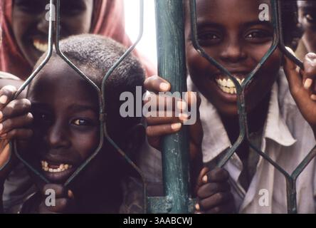 1 agosto 1992; Mogadiscio, SOMALIA; i ragazzi piccano attraverso il cancello fuori dall'ospedale Dikfer a Mogadiscio. Una ONG americana, International Medical Corps, sta fornendo personale all'ospedale e sta lavorando con volontari somali per curare e operare sui somali feriti nei combattimenti in corso. Credito obbligatorio: Foto di Cheryl Hatch/ZUMA Press. (©) Copyright 1992 di Cheryl Hatch Foto Stock