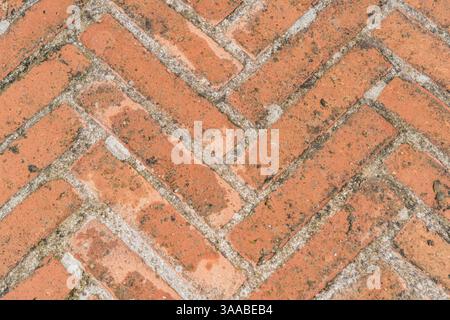 Pavimento in mattoni con motivo a diamante a Gubbio, Umbria. I mattoni sono rossi e bianchi. Il pattern è composto da quadrati e triangoli Foto Stock