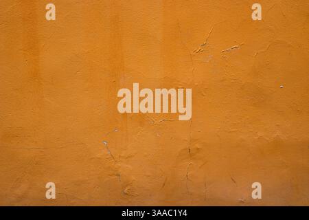 Primo piano di una parete arancione che mostra la sua consistenza e le sue imperfezioni naturali, perfetto per progetti di background e design, Vertical Mage mostra la deca urbana Foto Stock