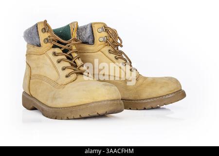 Stivali da trekking vintage in pelle gialla con lacci in un look da indossare. Il beige usava scarpe militari con suole spesse. Isolato su sfondo bianco. Lig. Studio Foto Stock