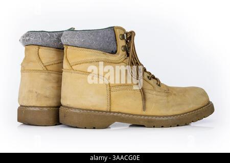 Stivali da trekking vintage in pelle gialla con lacci in un look da indossare. Il beige usava scarpe militari con suole spesse. Isolato su sfondo bianco. Lig. Studio Foto Stock