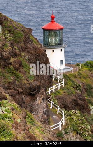 5 gennaio 2015 - Hawaii, Stati Uniti - Faro di Makapu'u all'estremità orientale dell'isola. O'ahu. Hawaii. Makapu'u Point Lighthouse è un faro attivo della Guardia Costiera degli Stati Uniti, alto 46 piedi (14 m), fondato nel 1909. La costruzione del faro è stata causata dalla messa a terra del piroscafo Manchuria nelle ore precedenti l'alba del 20 agosto 1906 sulle barriere coralline al largo di Waimānalo. Il faro fu automatizzato nel 1974 e i suoi quartieri di guardia demoliti nel 1987, ma i resti sono ancora visibili. Il faro contiene una lente iper-radiale Fresnel francese alta circa 3,7 m, la più grande lente in uso Foto Stock