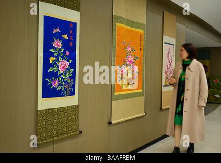 (250401) -- WUHAN, 1° aprile 2025 (Xinhua) -- Ren Wei Views espone i lavori di ricamo nel suo studio a Wuhan, nella provincia di Hubei, nella Cina centrale, 14 marzo 2025. Il ricamo Han, un ricamo tradizionale con una storia di oltre 2.000 anni, è stato elencato come uno dei patrimoni culturali immateriali nazionali nel 2008. Famoso per le sue cuciture ruvide, i colori ricchi e i motivi audaci, spesso delinea i motivi del ricamo con linee oro o argento, offrendo un magnifico impatto visivo. Ren Wei, nato in una famiglia di ricami Han, è un erede rappresentativo dell'arte. Da quando aveva 14 anni, Re Foto Stock