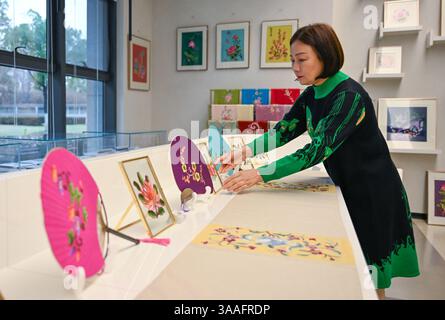 (250401) -- WUHAN, 1 aprile 2025 (Xinhua) -- Ren Wei organizza prodotti culturali e creativi nel suo studio a Wuhan, nella provincia di Hubei, nella Cina centrale, 14 marzo 2025. Il ricamo Han, un ricamo tradizionale con una storia di oltre 2.000 anni, è stato elencato come uno dei patrimoni culturali immateriali nazionali nel 2008. Famoso per le sue cuciture ruvide, i colori ricchi e i motivi audaci, spesso delinea i motivi del ricamo con linee oro o argento, offrendo un magnifico impatto visivo. Ren Wei, nato in una famiglia di ricami Han, è un erede rappresentativo dell'arte. Da quando aveva 14 anni Foto Stock