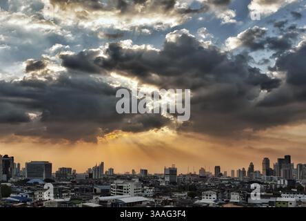 Vista della città al tramonto, il sole attraversa le nuvole Foto Stock