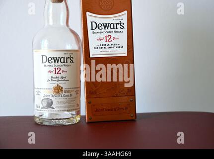 Bottiglia di whisky scotch Dewars e scatola per carte di credito su sfondo chiaro. Foto Stock