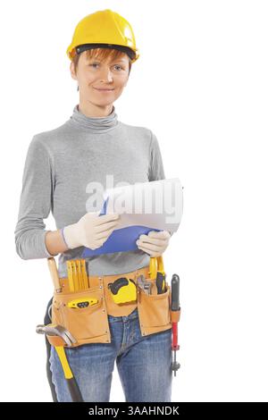 Donna che indossa abiti da lavoro e utensili da costruzione che tengono gli appunti con un foglio bianco e guardano la telecamera isolata su sfondo bianco Foto Stock