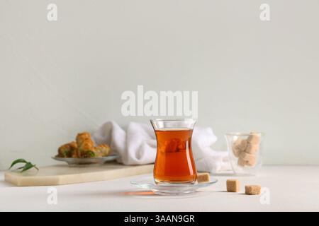 Bicchiere di tè turco con cubetti di zucchero su sfondo bianco Foto Stock
