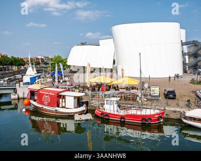 Barca da pesca che vende pesce fresco ormeggiata nel canale di Fährkanal con posti a sedere sul molo vicino a Ozeaneum a Stralsund, Meclemburgo-Vorpommern, Germania Foto Stock