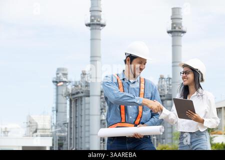 Team di ingegneri professionisti della raffineria petrolifera che si agitano a mano per gestire progetti di costruzione di petrolio e gas Foto Stock