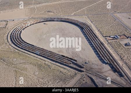 VISTA AEREA. Treni merci utilizzati per esportare i vari minerali estratti dai minerali della Valle del Searles a Trona. Contea di San Bernardino, California, Stati Uniti. Foto Stock