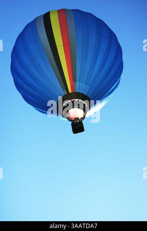 Pallone blu vibrante che galleggia contro un cielo limpido, simboleggia trasporti sostenibili ed ecologici, trasporti ecologici innovativi ed ecolog Foto Stock
