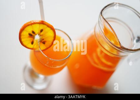 Caraffa in vetro e bicchiere riempito con succo d'arancia. Fotografia d'archivio Foto Stock