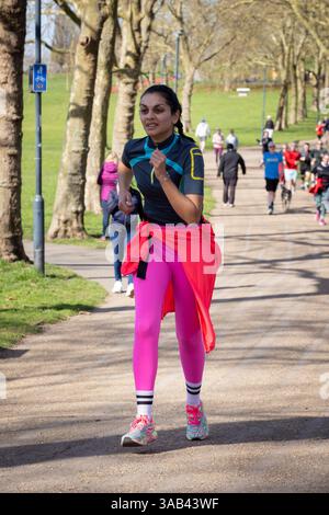 Parkrun a Gladstone Park, Londra Willesden NW2. Una giovane donna asiatica alla corsa settimanale per tutte le abilità. Foto Stock