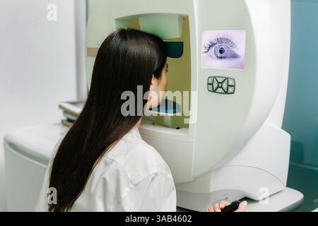 Perimetria occhi test per segno precoce di glaucoma di donna paziente di oftalmologia clinica. Test del campo visivo di perimetria per misurare tutte le aree della vista Foto Stock