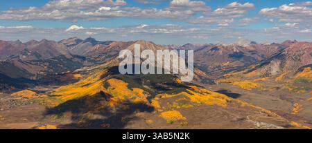 La montagna Gotica (631 metri) appare come un'isola in un mare di picchi della catena degli alci circondato da vivaci alberi di pioppo vicino a Crested Butte Colorado. Foto Stock