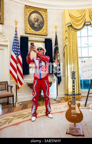 Washington, Stati Uniti. 31 marzo 2025. Il musicista Kid Rock, scatta un selfie con la dichiarazione di indipendenza, prima di firmare un ordine esecutivo che vieta lo scalping del biglietto sfruttativo presso l'Ufficio ovale della Casa Bianca, 31 marzo 2025 a Washington, DC Credit: Molly Riley/White House Photo/Alamy Live News Foto Stock