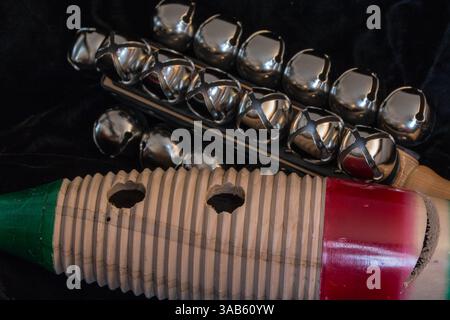 Strumenti orchestrali a percussione guiro e campane di slitta su sfondo nero. Foto Stock