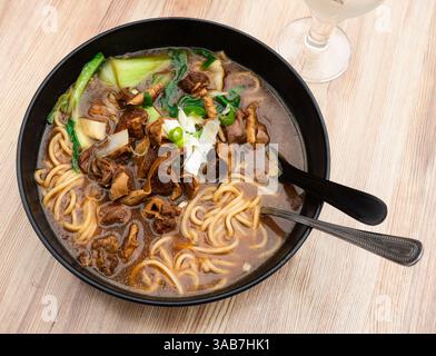 Zuppa di manzo con spaghetti e verdure su fondo di legno Foto Stock