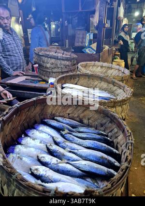Cesti di pesce fresco sgombro con venditori e acquirenti al Senen Market di Giacarta, Indonesia. Foto Stock