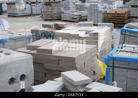 Materiali da costruzione impilati in un cantiere durante il giorno Foto Stock