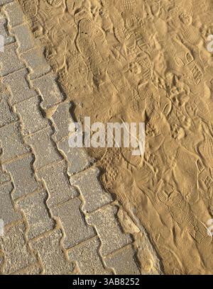 Lascia tracce di scarpe sulla sabbia vicino alla piramide a gradoni di Djoser a Saqqara, in Egitto Foto Stock