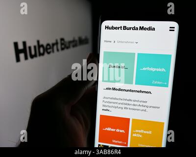 Germania. 7 marzo 2025. In questa illustrazione fotografica, una persona ha in mano una pagina web con il logo della società tedesca Hubert Burda Media che tiene KG sullo schermo davanti al logo. (Immagine di credito: © Timon Schneider/SOPA Images via ZUMA Press Wire) SOLO PER USO EDITORIALE! Non per USO commerciale! Foto Stock