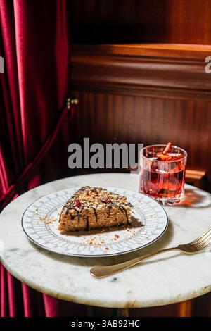 Una deliziosa torta a base di waffle ricoperta di latte condensato cremoso al tartufo, ricoperta da gocciolatoio di cioccolato, noci e ciliegie secche. Perfetto per un lusso Foto Stock
