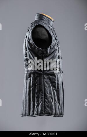 Giacca senza maniche in pelle nera con allacciatura e fibbie. Questa immagine mostra una giacca o un gilet senza maniche in pelle nera con collo alto. È dotato di de Foto Stock