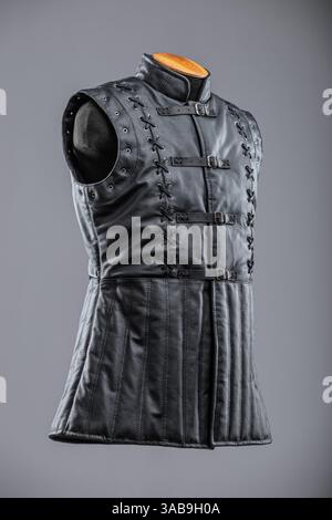 Giacca senza maniche in pelle nera con allacciatura e fibbie. Questa immagine mostra una giacca o un gilet senza maniche in pelle nera con collo alto. È dotato di de Foto Stock