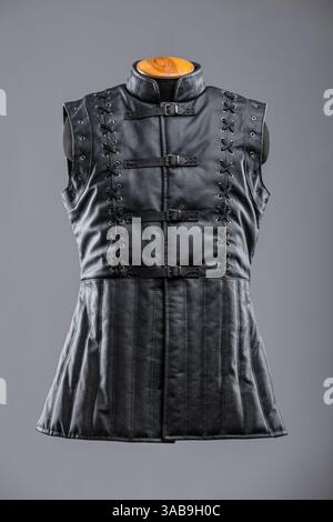Giacca senza maniche in pelle nera con allacciatura e fibbie. Questa immagine mostra una giacca o un gilet senza maniche in pelle nera con collo alto. È dotato di de Foto Stock
