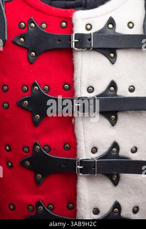 Primo piano dei dettagli dell'armatura rossa e bianca delle Brigandine. Questa immagine fornisce un dettaglio ravvicinato dell'armatura rossa e bianca dei briganti, mostrando i reggiseni Foto Stock
