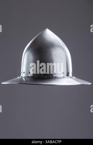 Cappello da bollitore medievale in acciaio lucido. Vista frontale di un casco medievale in acciaio lucido con cupola a punta, ampio bordo e rivetti su un Foto Stock