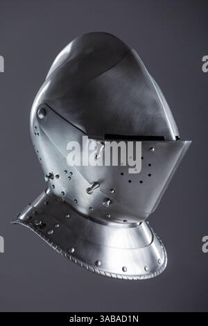 Elmetto con armatura medievale in argento lucido con visiera. Questo rivestimento in argento lucido è dotato di visiera incernierata e smusso, per una protezione completa della testa in stile medievale Foto Stock