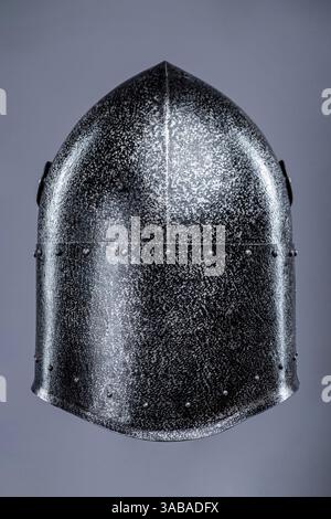 Elmetto da cavaliere medievale chiuso con piccole perforazioni. Questa immagine mostra un casco da cavaliere medievale chiuso, probabilmente in acciaio, con una parte superiore appuntita Foto Stock