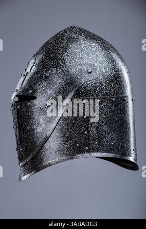 Elmetto da cavaliere medievale chiuso con piccole perforazioni. Questa immagine mostra un casco da cavaliere medievale chiuso, probabilmente in acciaio, con una parte superiore appuntita Foto Stock