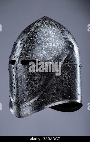 Elmetto da cavaliere medievale chiuso con piccole perforazioni. Questa immagine mostra un casco da cavaliere medievale chiuso, probabilmente in acciaio, con una parte superiore appuntita Foto Stock