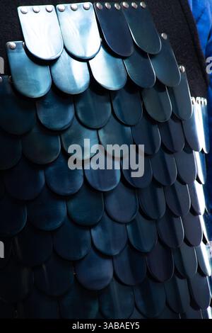 Primo piano di scale dell'armatura lamellare bizantina. Vista dettagliata delle piastre metalliche sovrapposte su un'armatura in scala medievale. Foto Stock