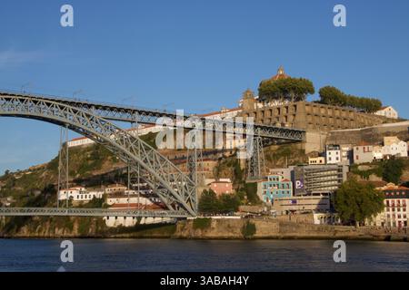 Ponte Dom Luís i sul fiume Douro, che collega Porto a Vila Nova de Gaia, in Portogallo, con paesaggio urbano e cieli limpidi sullo sfondo. Foto Stock