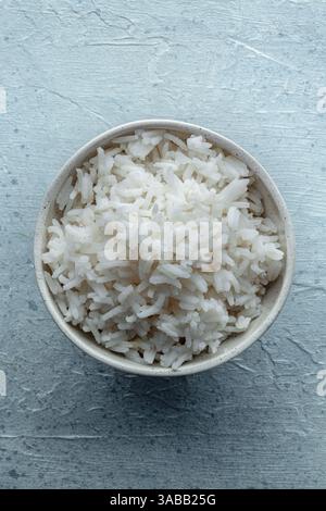 Riso bianco, cotto. Una ciotola di riso a grani lunghi bollito, un semplice contorno, sparato dall'alto Foto Stock