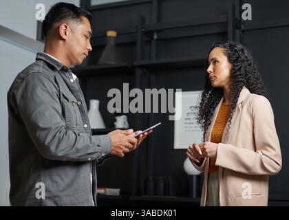 Due professionisti si sono impegnati in una conversazione sull'attività aziendale in un ambiente di ufficio Foto Stock