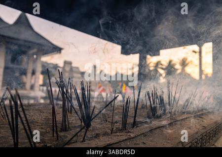 Primo piano di bastoncini di incenso bruciati di fumo nell'antico tempio buddista. Kandy, Sri Lanka. Foto Stock