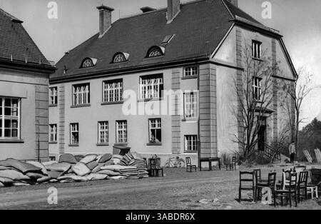 Vista dell'ufficio del primo comandante nel campo di concentramento di Dachau, con mobili e materassi per le guardie in primo piano. [traduzione automatizzata] Foto Stock