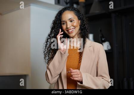 Donna professionista sicura in ufficio che si occupa di una conversazione telefonica Foto Stock