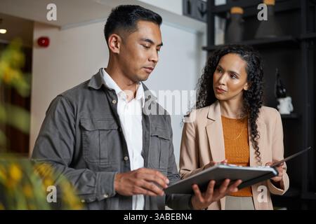 Due professionisti si sono impegnati in una discussione in un ambiente di ufficio moderno Foto Stock