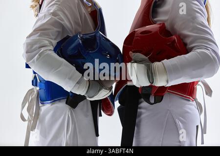 Due atleti taekwondo che premono i caschi insieme in un potente gesto simbolico di rivalità e sportività. Foto Stock