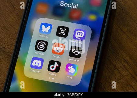 App di social networking assortite, tra cui Bluesky, X, Mastodon, thread, Reddit, Spill, Discord, TikTok e HIVE sono visualizzati sullo schermo di un iPhone. Foto Stock