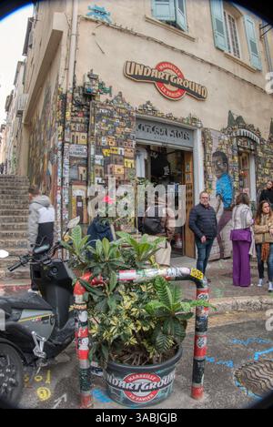 Marsiglia, Francia - 25 marzo 2024: Persone che fanno shopping in un negozio con una facciata splendidamente decorata nel quartiere turistico del quartiere le Panier. Foto Stock