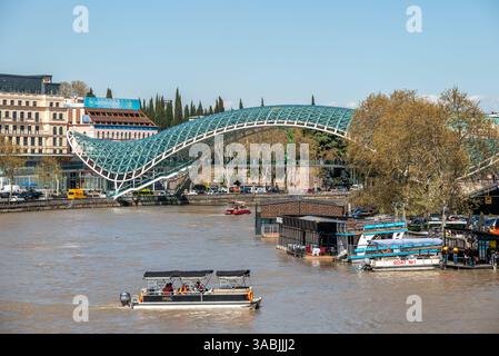Ponte di pace, ponte pedonale in acciaio e vetro sul fiume Kura Mtkvari nel centro di Tbilisi, capitale della Georgia, il 1° aprile 2025 Foto Stock
