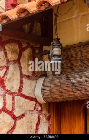 Lanterna rustica appesa all'esterno di un edificio in pietra e legno Foto Stock